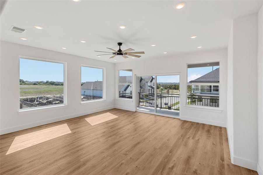 Empty room with light hardwood / wood-style floors and ceiling fan