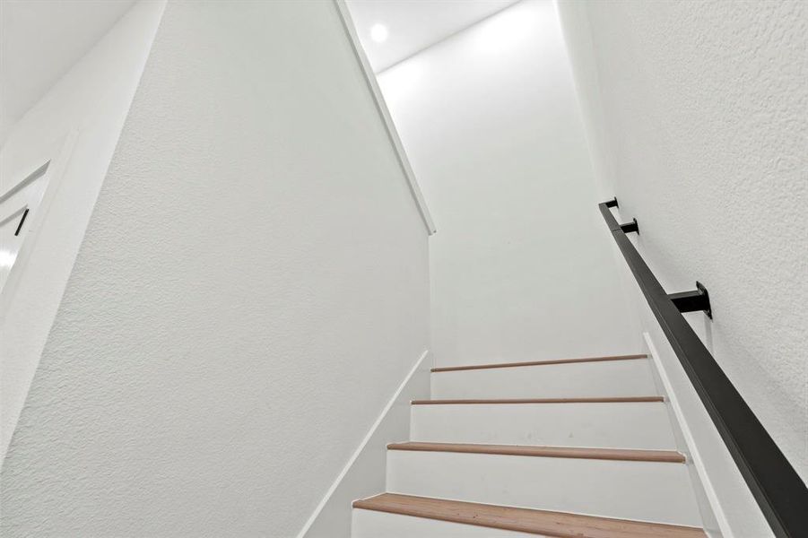 Staircase featuring a textured wall Staircase featuring a textured wall