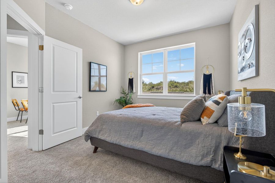 Bedroom featuring light colored carpet and baseboards