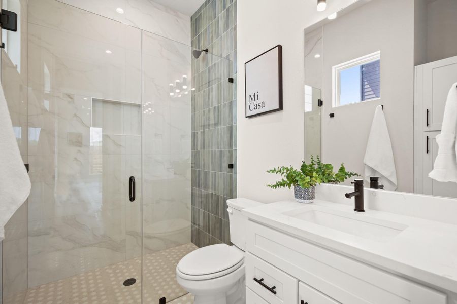 Bathroom featuring a marble finish shower and vanity