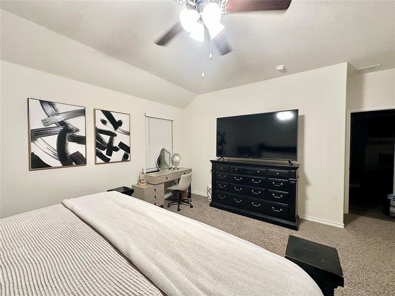 Bedroom featuring vaulted ceiling, light carpet, a ceiling fan, and a desk Bedroom featuring vaulted ceiling, light carpet, a ceiling fan, and a desk