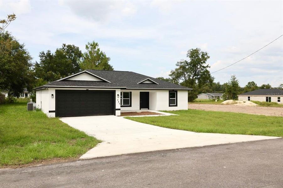 Front exterior of a new home in , Ocklawaha, FL, highlighting curb appeal (Image 1).