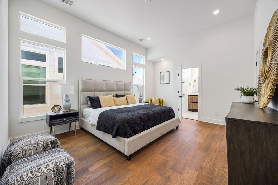 Spacious primary bedroom flooded with lots of natural light, located on the third floor.