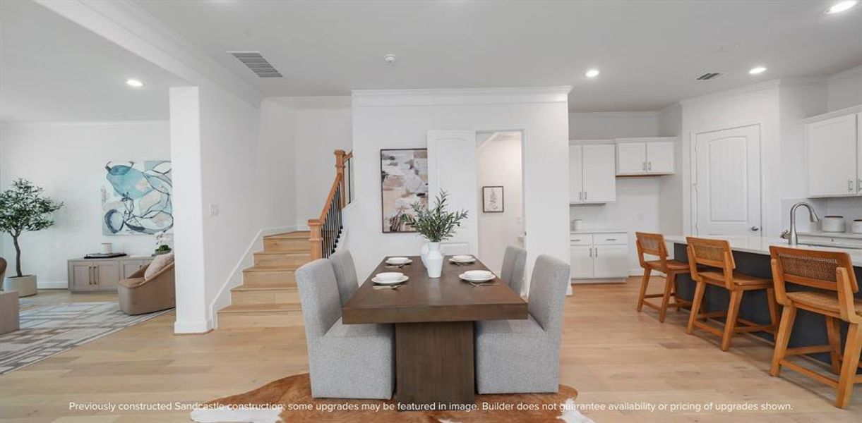 Elegant Ascension: The warm glow of wood floors not only grounds the dining room but also ascends, drawing the eye and spirit upward to the private sanctuaries above.