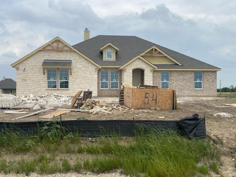 Stone and brick exterior with a prominent front-facing gable featuring decorative wood accents