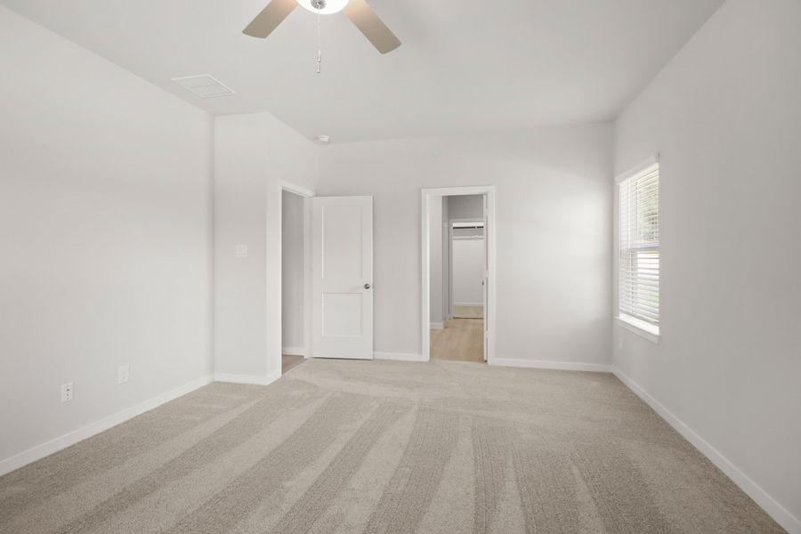 A room with a ceiling fan and a door.
