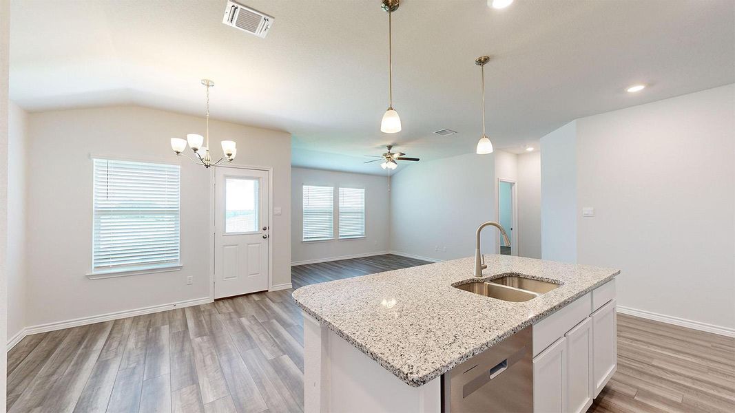 Kitchen featuring white cabinets, light stone counters, ceiling fan, stainless steel dishwasher, and light wood finished floors