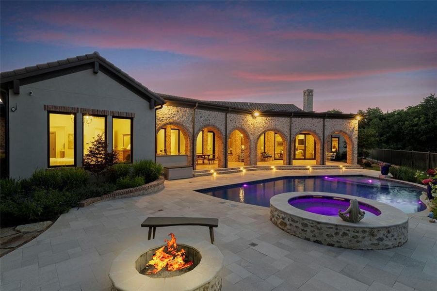 Rear view of house with an in-ground hot tub, a patio area, a fire pit, a chimney, and a tile roof Rear view of house with an in-ground hot tub, a patio area, a fire pit, a chimney, and a tile roof