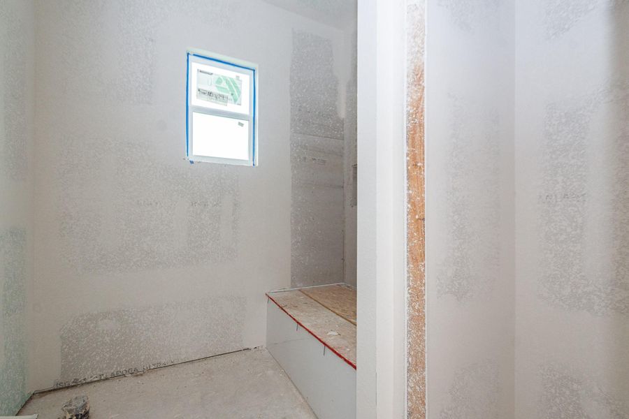 Spacious unfinished secondary bathroom with a single window, offering potential for customization and natural light. Spacious unfinished secondary bathroom with a single window, offering potential for customization and natural light.