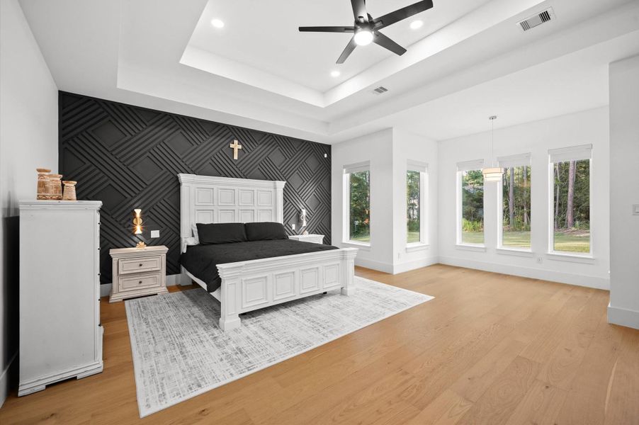 Oversized primary suite with peaceful backyard views. Large windows fill the room with natural light.