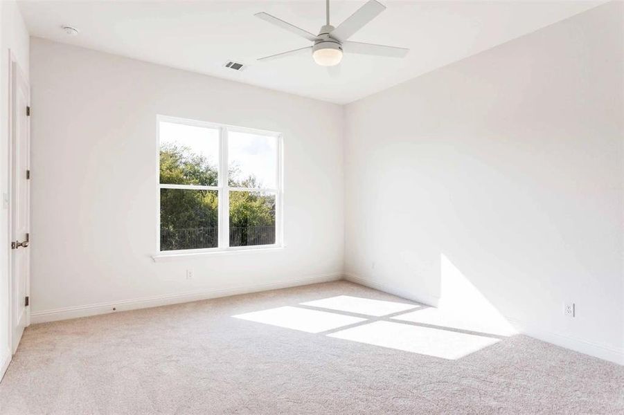 Spare room with light carpet and a ceiling fan
