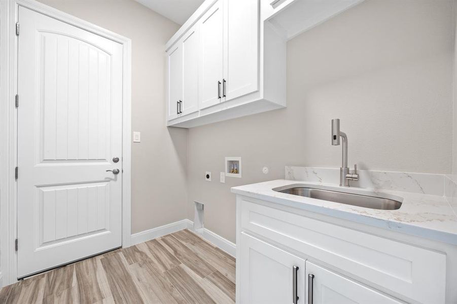 Laundry room with hookup for a washing machine, sink, cabinets, and electric dryer hookup