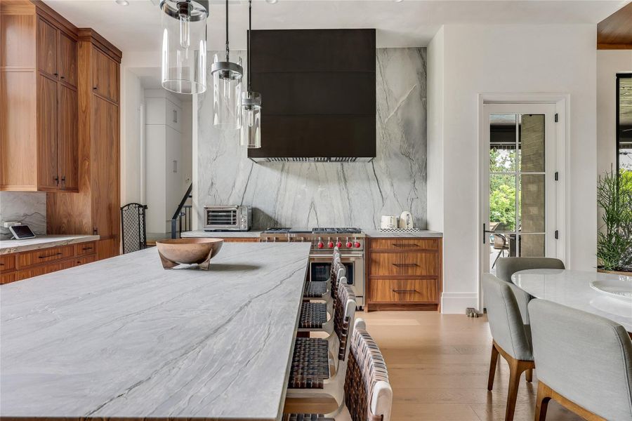 A gourmet kitchen boasts custom walnut cabinetry and an oversized island with built-in storage.