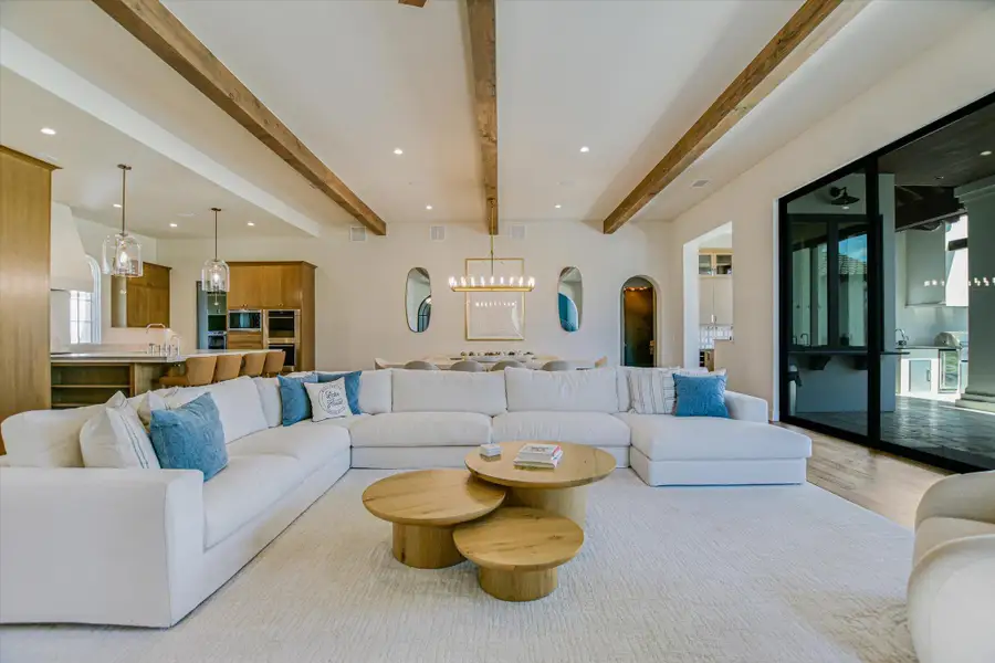 Living room featuring recessed lighting, arched walkways, wood finished floors, and beamed ceiling