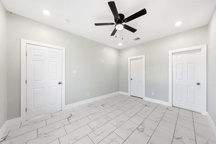 Unfurnished bedroom with light marble finish floors, a ceiling fan, and recessed lighting