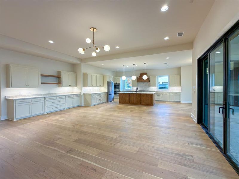 Expansive open-concept living space with wood-finish flooring
