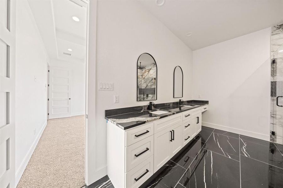 Bathroom with double vanity, baseboards, recessed lighting, and a shower Bathroom with double vanity, baseboards, recessed lighting, and a shower