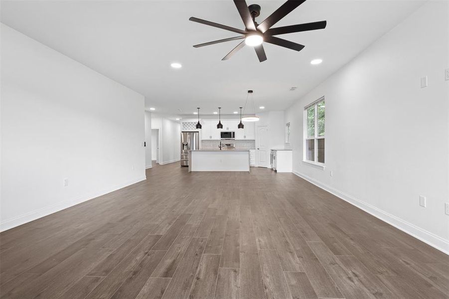 Unfurnished living room featuring recessed lighting, dark wood-type flooring, and a ceiling fan