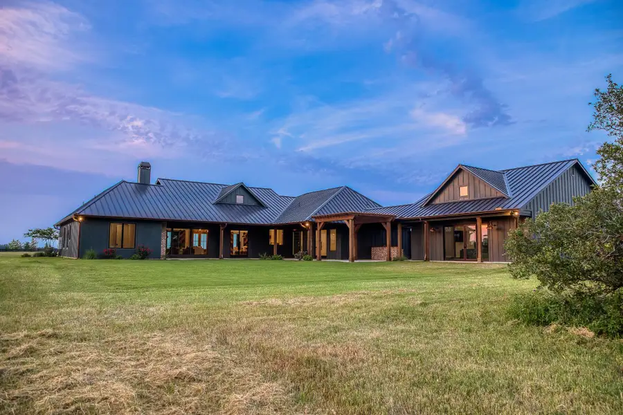 View of front of property with a metal roof, a standing seam roof, board and batten siding, and a front lawn View of front of property with a metal roof, a standing seam roof, board and batten siding, and a front lawn