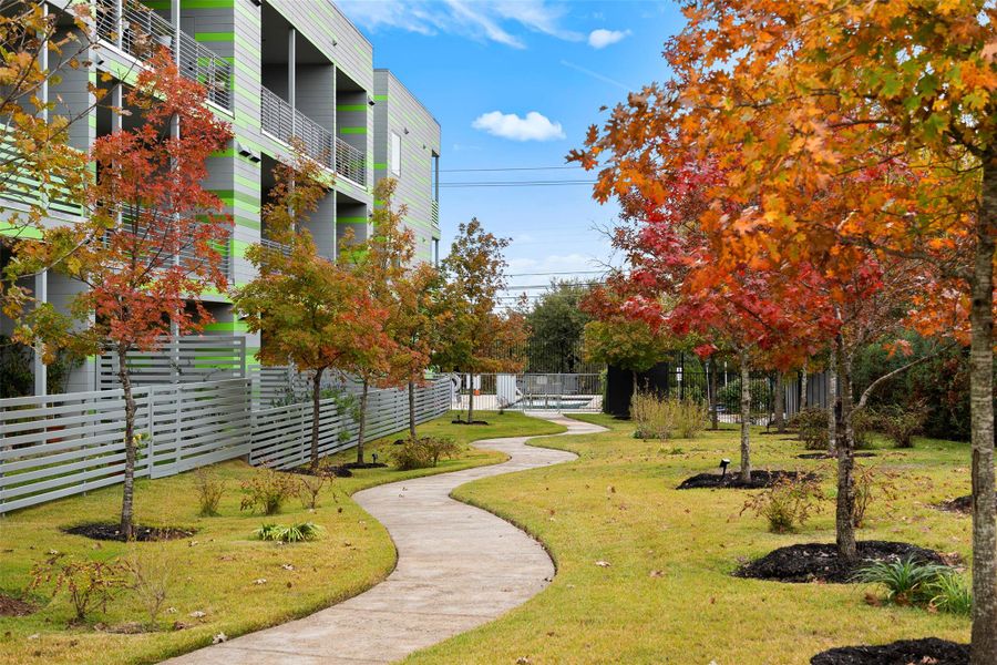 View of home's community with fence and a lawn