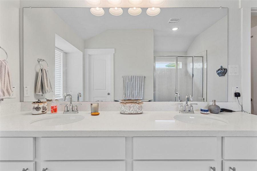 Bathroom featuring double vanity, a stall shower, and lofted ceiling Bathroom featuring double vanity, a stall shower, and lofted ceiling