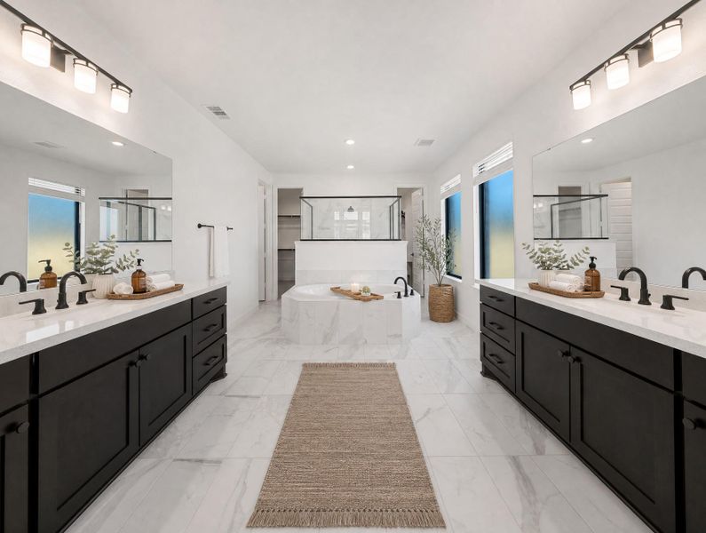 Marble tile flooring extends through this primary bathroom, featuring dual vanities and a soaking tub. Marble tile flooring extends through this primary bathroom, featuring dual vanities and a soaking tub.