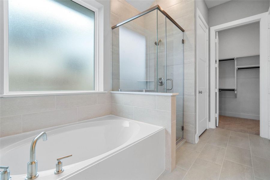 Additional view of the primary bathroom showcasing the built-in soaking tub and walk-in shower.