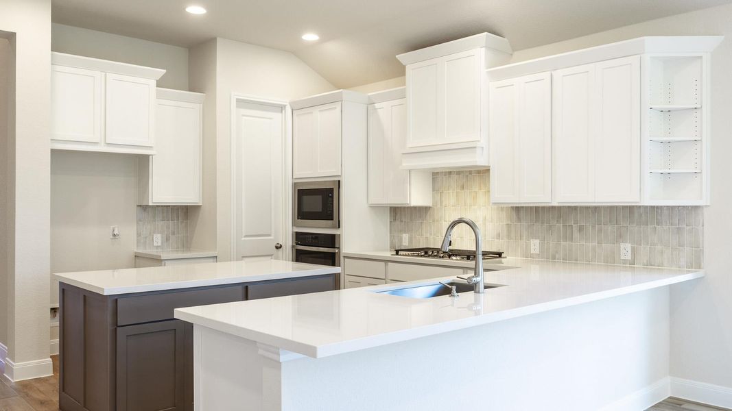 Kitchen with a center island, open shelves, white cabinets, a peninsula, and wood finished floors Kitchen with a center island, open shelves, white cabinets, a peninsula, and wood finished floors
