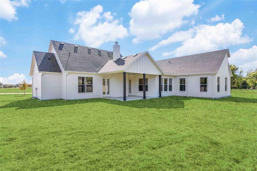 Back of property featuring a shingled roof, a yard, and a patio Back of property featuring a shingled roof, a yard, and a patio