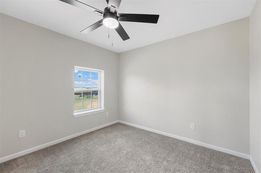 Carpeted spare room featuring baseboards and a ceiling fan Carpeted spare room featuring baseboards and a ceiling fan
