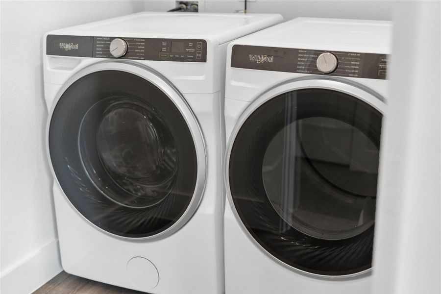 This bright and functional laundry room is conveniently located and is equipped with a Whirlpool washer and dryer set. It features clean white walls and trim and laminate flooring. This bright and functional laundry room is conveniently located and is equipped with a Whirlpool washer and dryer set. It features clean white walls and trim and laminate flooring.