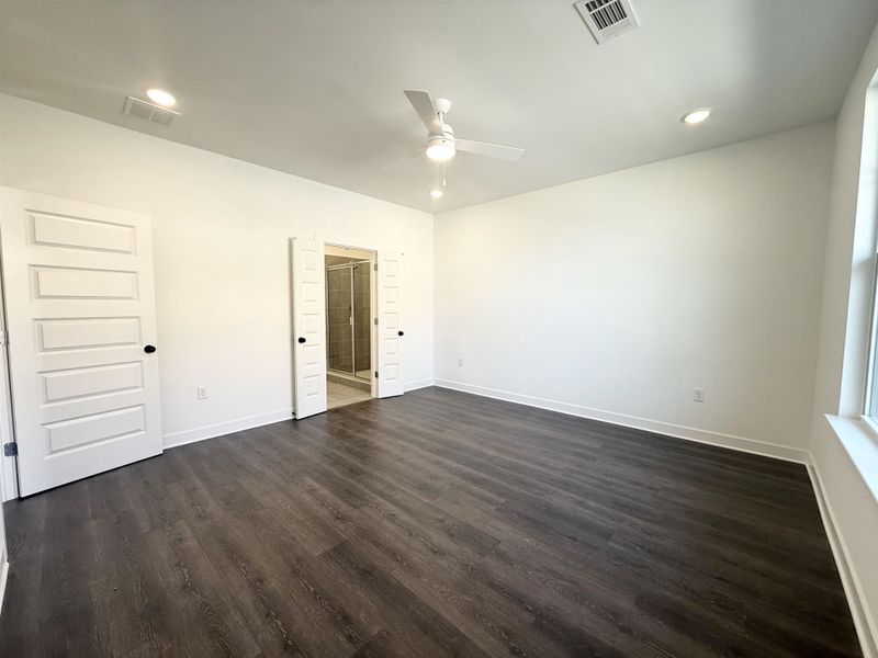 Unfurnished bedroom featuring ceiling fan, recessed lighting, dark wood-style floors, and ensuite bath