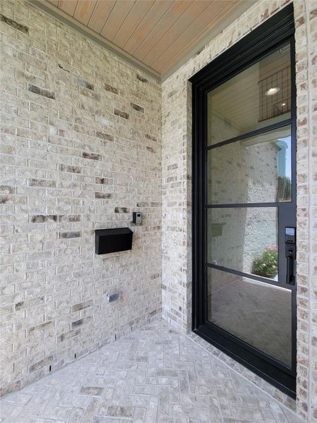 Grand front entry highlighted by an impressive 10-foot steel front door, creating a striking first impressionwith smart lock system provides modern convenience, enhanced security, and keyless access for everyday living.The welcoming covered porch features timeless herringbone-pattern brick flooring, adding character and architectural charm. Grand front entry highlighted by an impressive 10-foot steel front door, creating a striking first impressionwith smart lock system provides modern convenience, enhanced security, and keyless access for everyday living.The welcoming covered porch features timeless herringbone-pattern brick flooring, adding character and architectural charm.