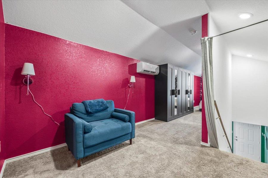 Living area with a textured wall, light carpet, and a textured ceiling Living area with a textured wall, light carpet, and a textured ceiling