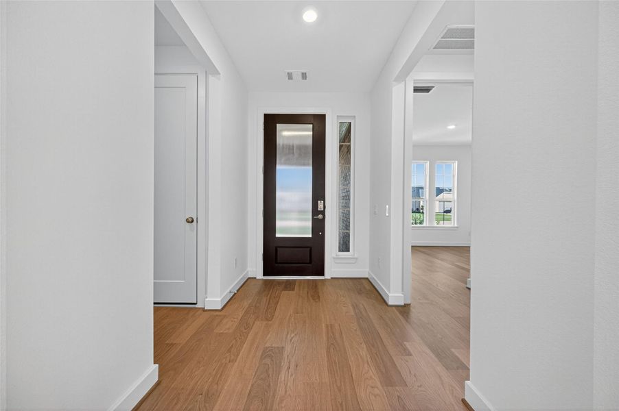 This inviting entryway sets the perfect first impression with a bright open, and modern look. The sleek front door with frosted glass welcomes natural light while maintaining privacy.