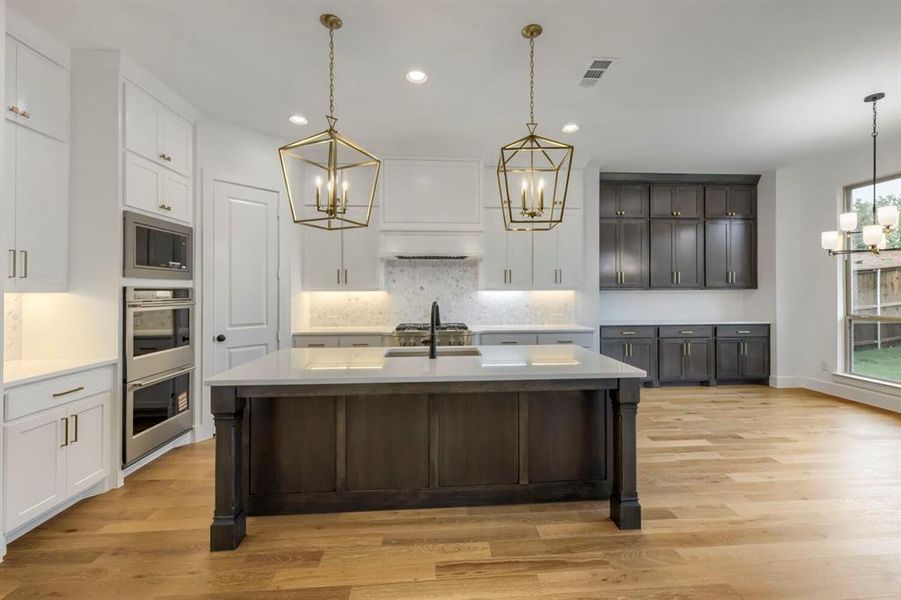The kitchen features a large island with a dark wood base and a light-colored countertop