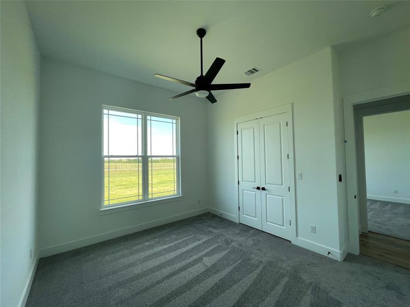Unfurnished bedroom with carpet floors, a closet, and a ceiling fan Unfurnished bedroom with carpet floors, a closet, and a ceiling fan