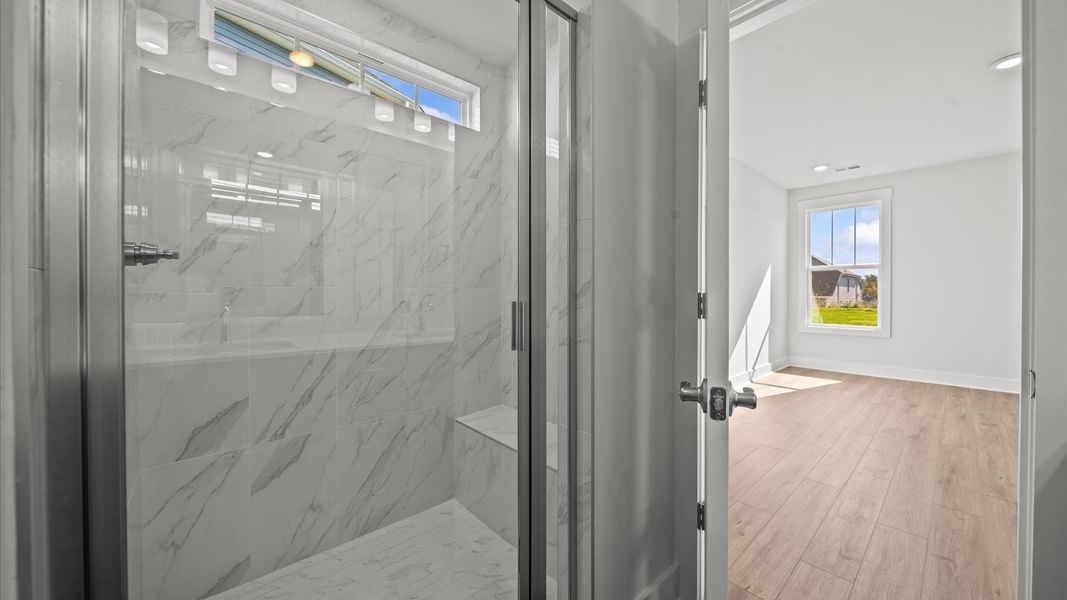 Exceptional en-suite with dual vanity and glass-enclosed tiled walk-in shower for superior everyday comfort