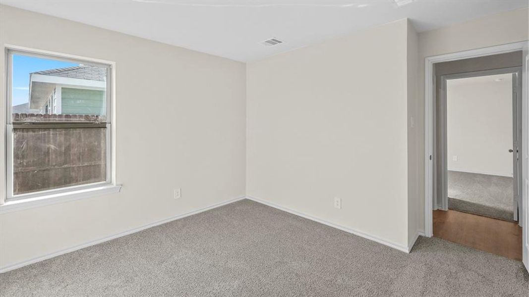 Carpeted spare room featuring baseboards