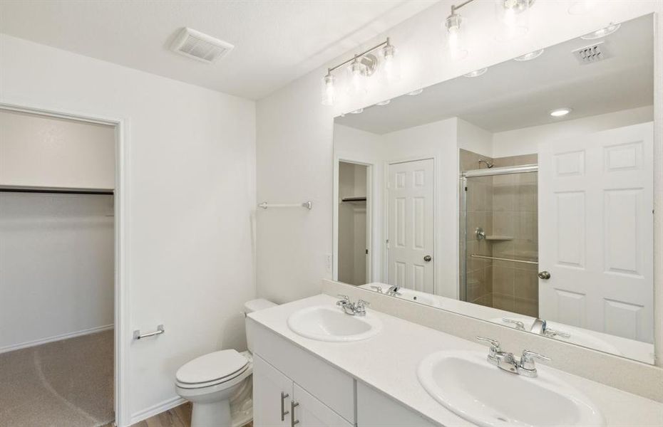 Upgraded owner's bath with dual vanity and oversized shower *real home pictured