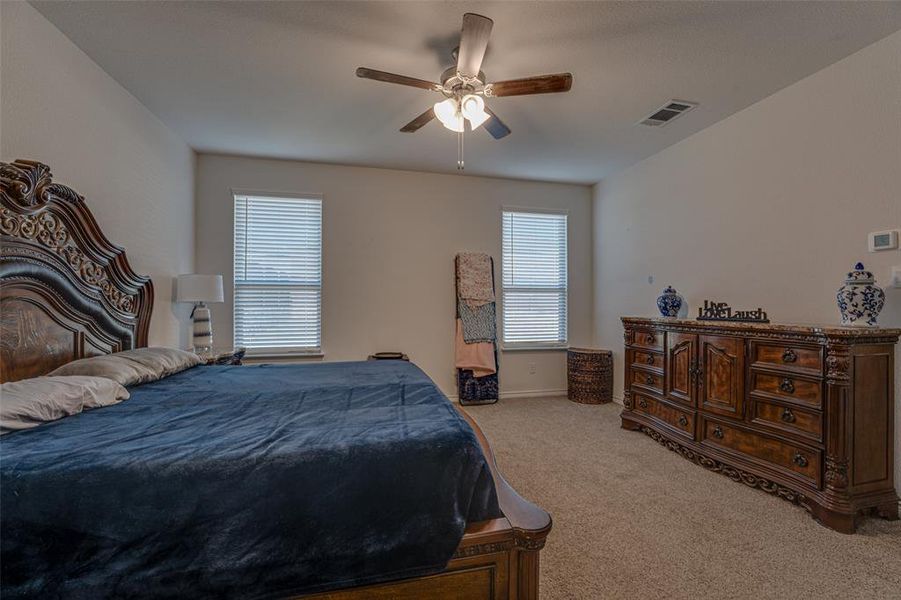 Bedroom with light colored carpet and a ceiling fan