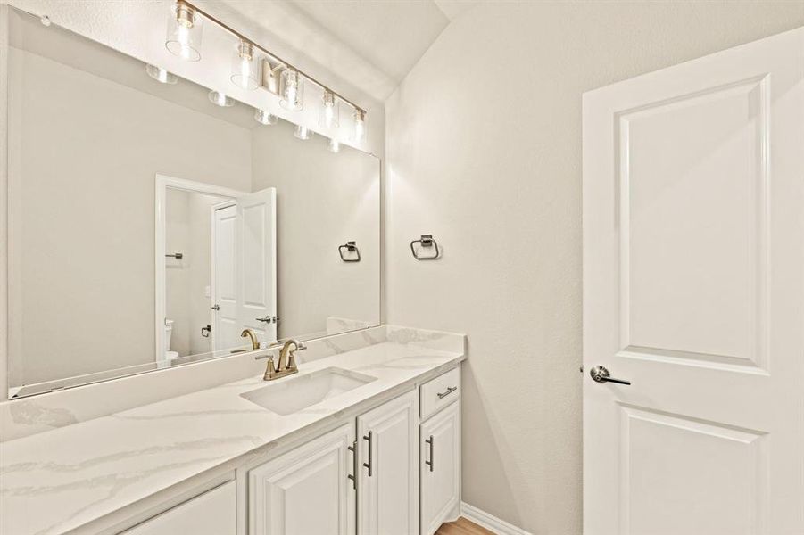 Bathroom with vanity and vaulted ceiling
