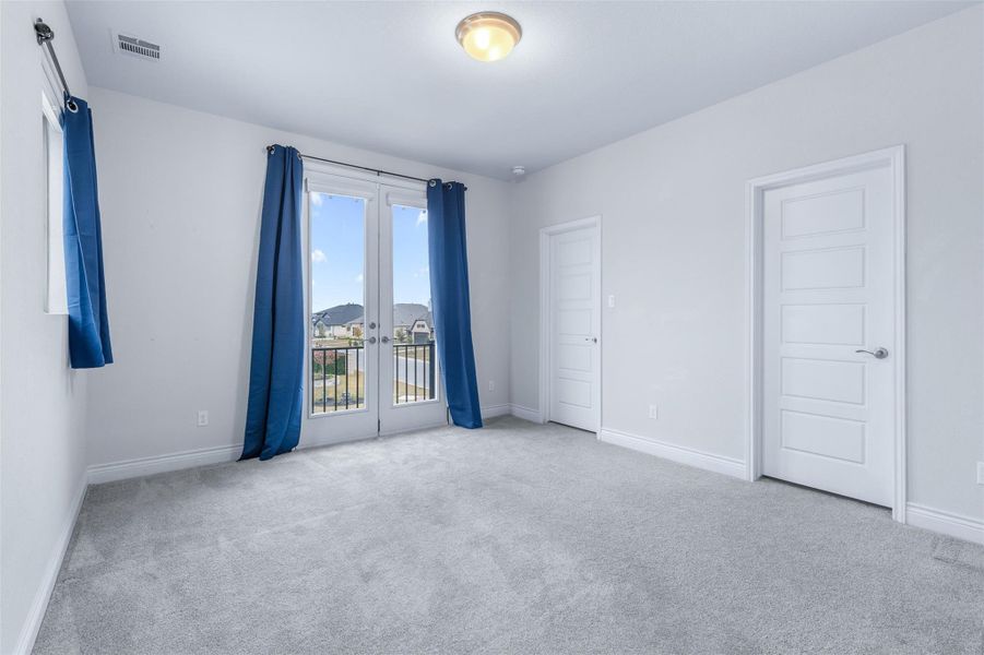 Unfurnished room with light carpet and french doors