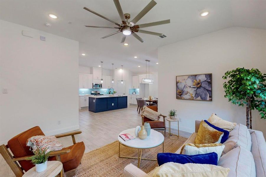 Living room with ceiling fan and light hardwood / wood-style floors