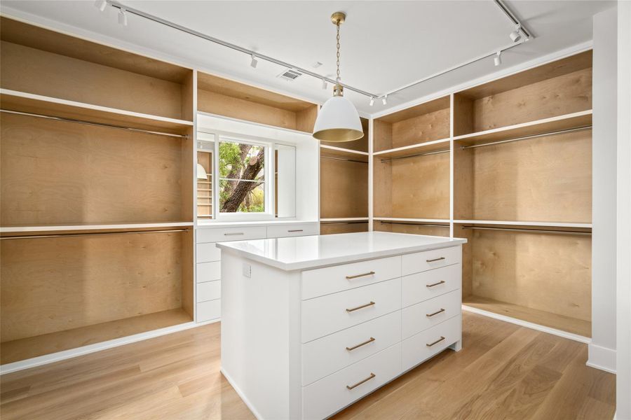 Designed for both style and utility, the primary closet offers a central island, generous storage, and a clean, tailored layout throughout.