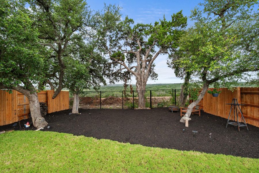 A private, fenced backyard offers a tranquil retreat with mature trees and verdant views. A private, fenced backyard offers a tranquil retreat with mature trees and verdant views.