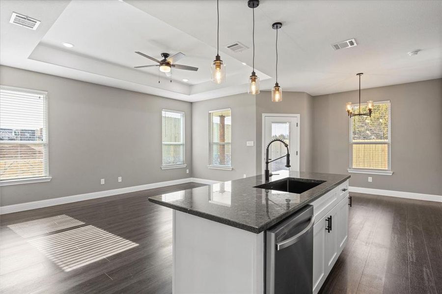 Kitchen open to living and dining areas.  Note the tray ceiling and high end finishes throughout.