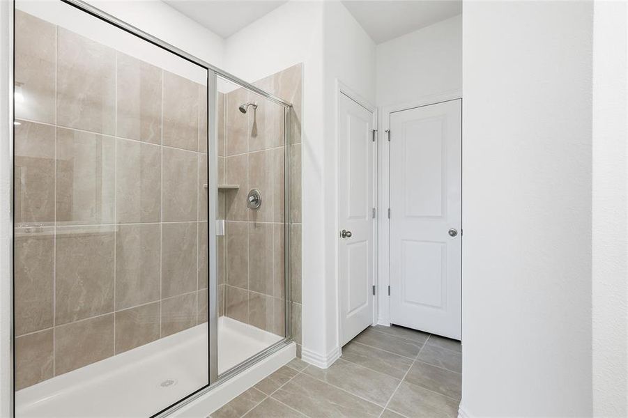 Bathroom featuring a stall shower and light tile patterned floors