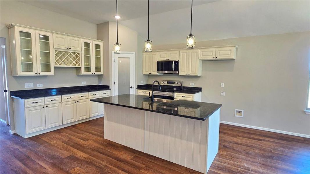Kitchen featuring appliances with stainless steel finishes, dark wood finished floors, glass insert cabinets, and high vaulted ceiling