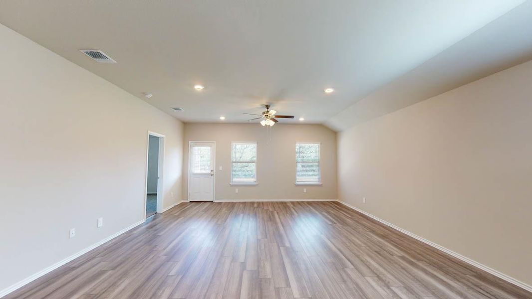 Laminate wood flooring and bright recessed lighting create an inviting living space.